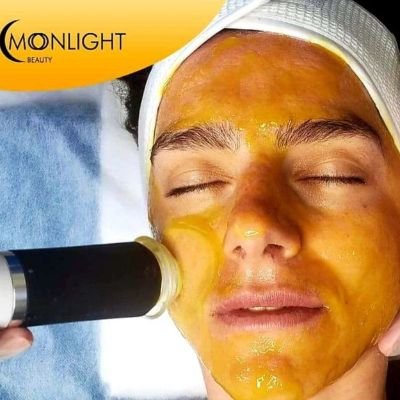 Person undergoing a gold facial treatment at Moonlight Beauty.